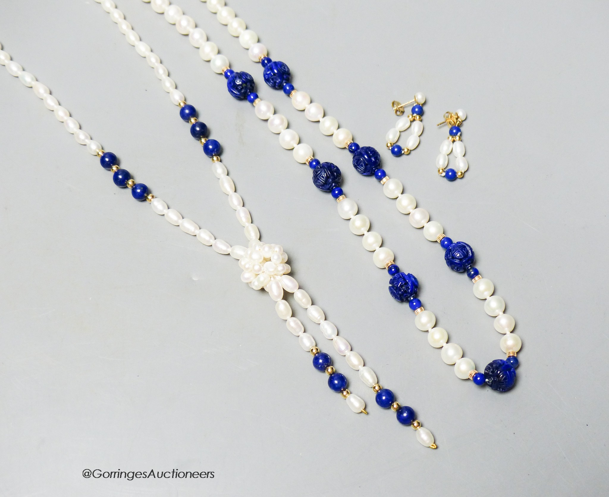 A modern freshwater pearl and lapis lazuli drop necklace with 14k clasp, 64cm, a pair of matching earrings and a similar necklace with 9ct clasp.